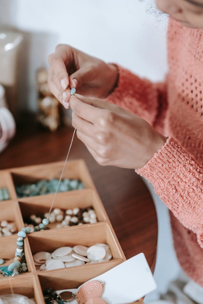 our-services-01 Anonymous female arranging beads and blue natural stones on fishing line while doing handmade bijouterie